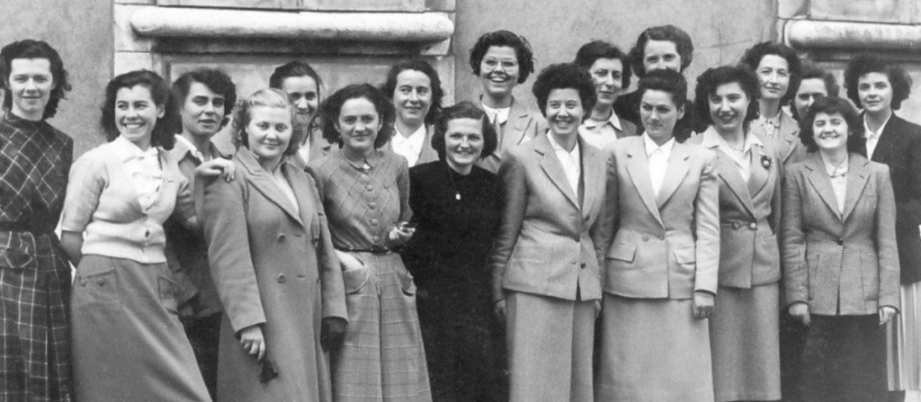 Photo d’archive d’un groupe de femmes posant ensemble devant un bâtiment.