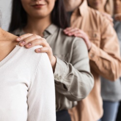 Personnes en file indienne se touchant l'épaule.