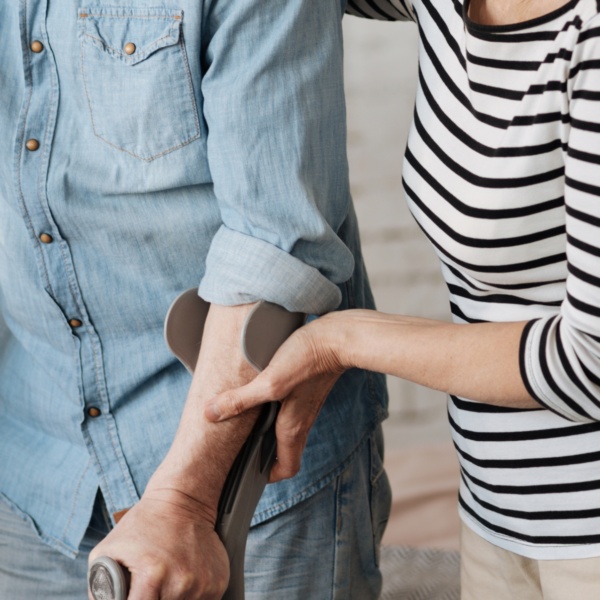 Personne aidant un autre avec une béquille.