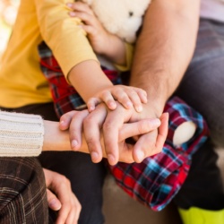 Mains d'une famille réunies, symbolisant l'unité.