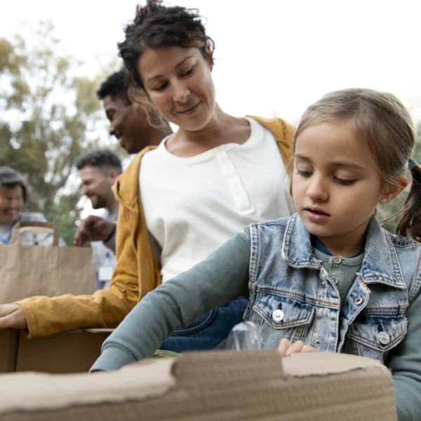 Une fille aide à distribuer des boîtes alimentaires.